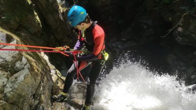 A Man At The Top Of A Waterfall Attached To Ropes While Canyoning In Vancouver