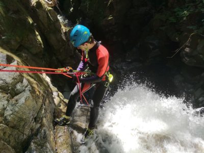A Man At The Top Of A Waterfall Attached To Ropes While Canyoning In Vancouver