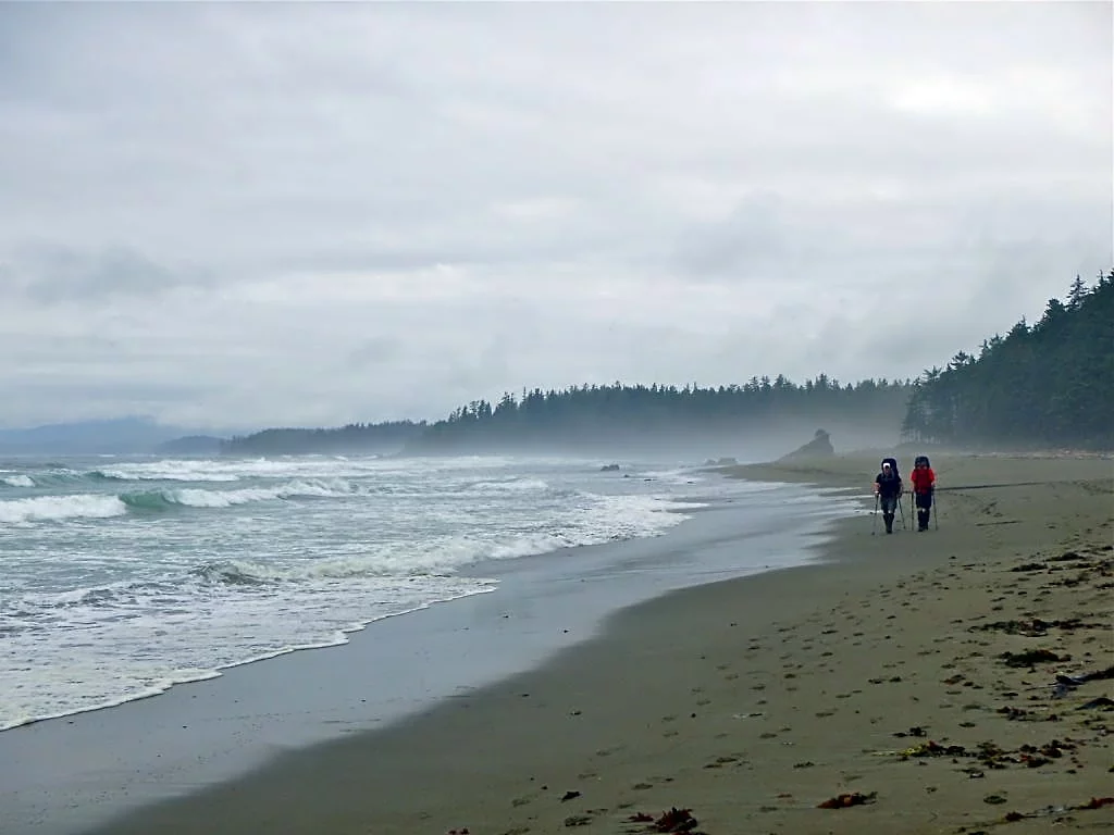 Two hikers on a beach on the West Coast Trail