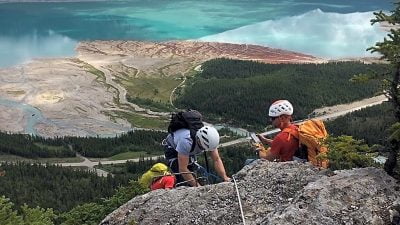 A Group Of Climbers At The Top Of Mt Stelfox With A Blue Lake Below