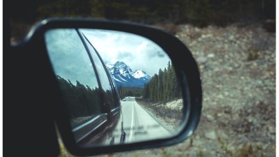 Rear View Mirror Showing Banff And The Canadian Rockies On A Road Trip