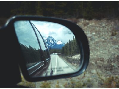 Rear View Mirror Showing Banff And The Canadian Rockies On A Road Trip